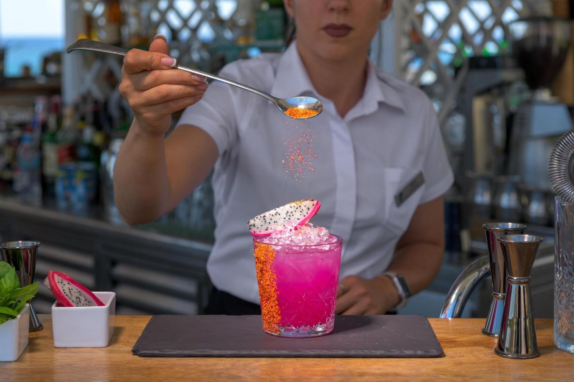 Rodos Palladium Leisure & Wellness Kallithea  Bagian luar foto A bartender adding a garnish to a cocktail